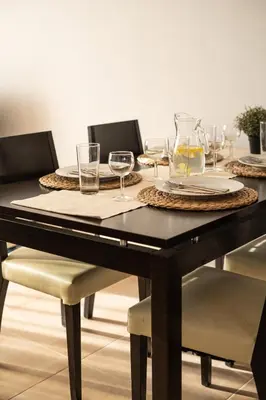 a dining room table with glasses and plates on it at 300m to Nissi Beach, Pool & Sunny Terrace in Ayia Napa