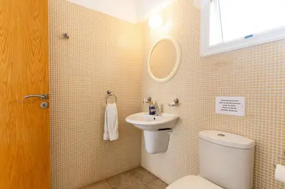 a bathroom with a toilet and a sink and a mirror at 300m to Nissi Beach, Pool & Sunny Terrace in Ayia Napa