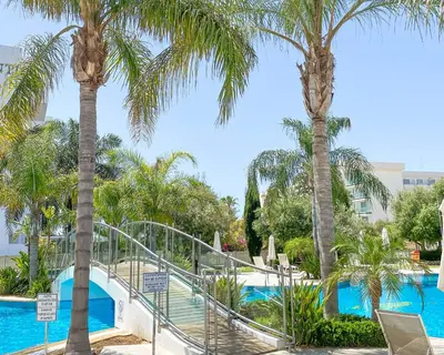 a resort with palm trees and a swimming pool at Anesis Hotel in Ayia Napa