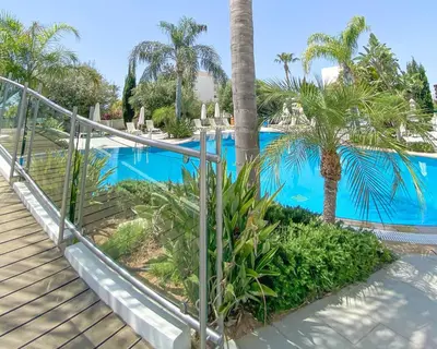 a staircase leading to a swimming pool with palm trees at Anesis Hotel in Ayia Napa