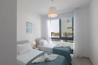 two beds in a room with a window at Protaras Aqua Pearl Villa in Protaras
