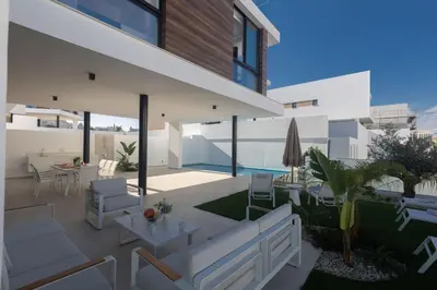 a modern house with white furniture and a patio at Protaras Aqua Pearl Villa in Protaras