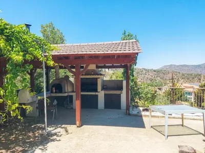 a pizza oven under a pavilion with a table at Orama Mountain Villa Farmakas in Nicosia