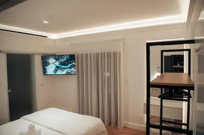 a bedroom with a bed and a television on the wall at Hyperion Boutique Villa in Voroklini