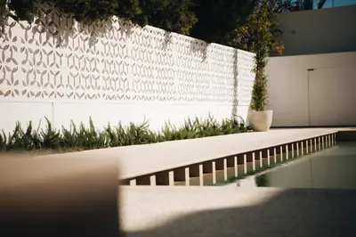 a white fence with a plant in front of it at Hyperion Boutique Villa in Voroklini