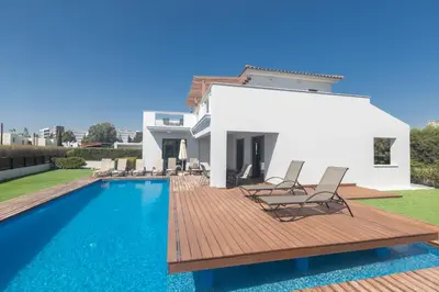 a villa with a swimming pool in front of a house at Sea Satin Villas - Ayia Napa Center in Ayia Napa