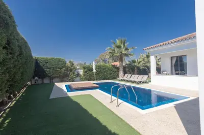 a swimming pool in a yard next to a house at Sea Satin Villas - Ayia Napa Center in Ayia Napa