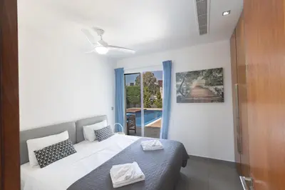 a bedroom with a bed and a large window at Sea Satin Villas - Ayia Napa Center in Ayia Napa