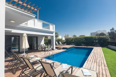 a villa with a swimming pool and chairs at Sea Satin Villas - Ayia Napa Center in Ayia Napa