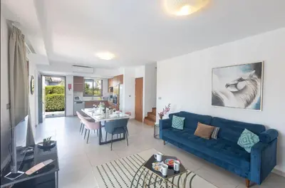 a living room with a blue couch and a table at Ayia Napa Satin Villa SVI3 in Ayia Napa