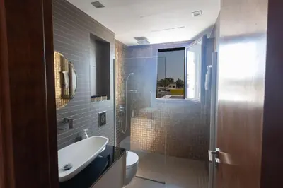 a bathroom with a sink and a toilet and a mirror at Ayia Napa Satin Villa SVI3 in Ayia Napa