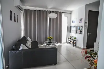 a living room with a black couch and a table at Hi royal villa in Pervolia