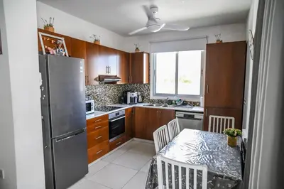 a kitchen with a table and a stainless steel refrigerator at Hi royal villa in Pervolia