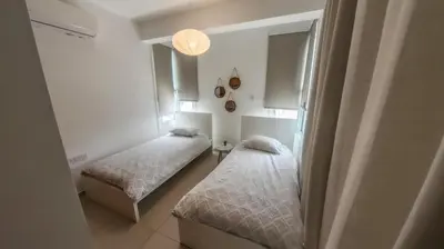a bedroom with two beds and a chandelier at Hi royal villa in Pervolia