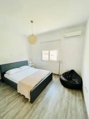 a bedroom with a bed and a black chair at LimassolStar Etko Area in Limassol