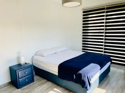a bedroom with a bed and a nightstand and a window at LimassolStar Etko Area in Limassol