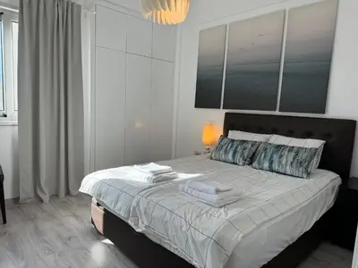 a bedroom with a large bed with towels on it at White 1-bdr apartment Agyos Tychonas in Limassol