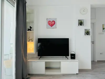 a living room with a television on a white wall at White 1-bdr apartment Agyos Tychonas in Limassol