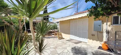 a patio with chairs and a building with a garage at Lydia's Sea View - 2 bed House in Episkopi Lemesou