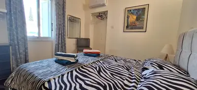 a zebra print bed in a bedroom with a window at Lydia's Sea View - 2 bed House in Episkopi Lemesou