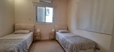 two twin beds in a room with a window at Lydia's Sea View - 2 bed House in Episkopi Lemesou