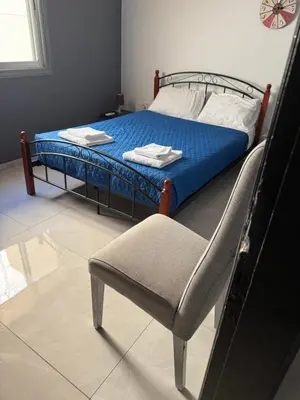 a bed and a chair in a room at D Pitsillos Homes luxury in Larnaka