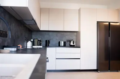 a kitchen with white cabinets and a refrigerator at Delightful 1st Floor Xanthippis Apartment in Strovolos