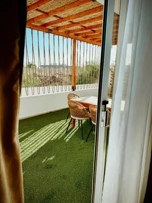 a room with a table and chairs on a balcony at Nissi Si Lux Boho Apartment on Nissi beach in Ayia Napa