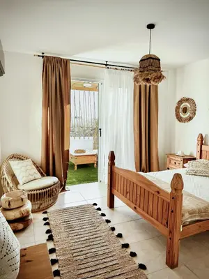 a bedroom with a bed and a couch and a window at Nissi Si Lux Boho Apartment on Nissi beach in Ayia Napa