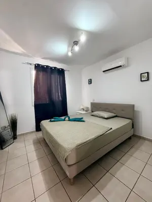 a bedroom with a bed in a white room at Kapparis Pleasure Familly Lounge in Paralimni