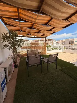 a patio with two chairs and a table under awning at Kapparis Pleasure Familly Lounge in Paralimni