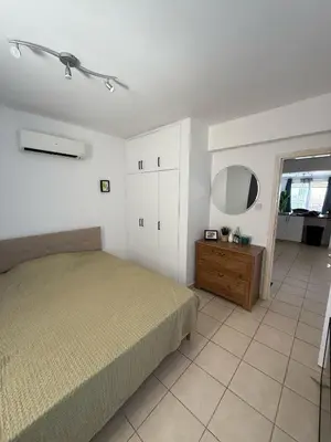 a bedroom with a bed and a mirror and a dresser at Kapparis Pleasure Familly Lounge in Paralimni