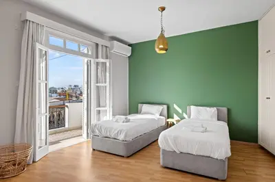 two beds in a room with a green wall at St Lazar Penthouse Apartment in Larnaka