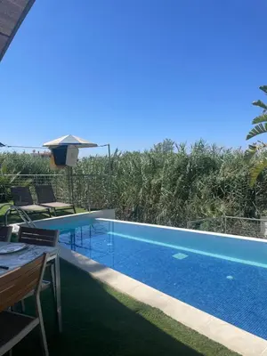 a swimming pool with a table and chairs next to it at Gold Sand Villa in Protaras