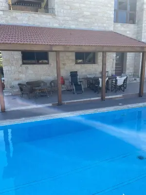 a pool with a pavilion and tables and chairs at Softades Cottage in Omodos