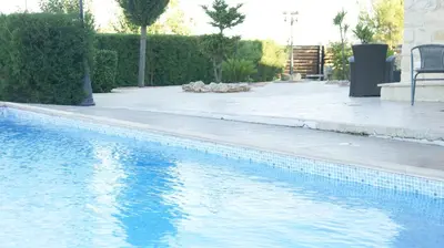 a swimming pool with blue water in a yard at Softades Cottage in Omodos