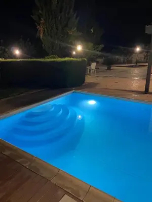 a blue swimming pool at night at Softades Cottage in Omodos