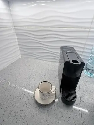 a coffee cup on a saucer next to a cell phone at Elegant 2BR Apartment- La Vie Royale in Nicosia