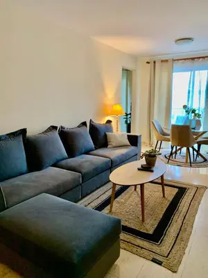 a living room with a blue couch and a table at Stylish Well-Equipped 2-bed flat in Nicosia Centre in Strovolos