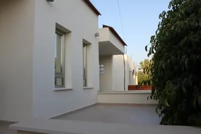 a white building with two windows and a courtyard at Modern spotless house with full privacy and WiFi in Aglantzia Nicosia in Aglantzia