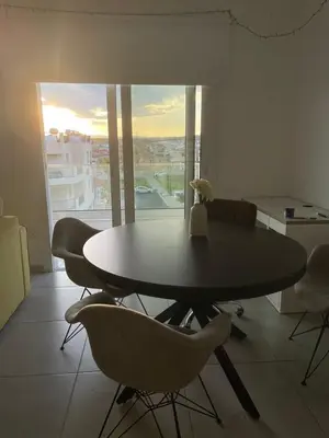a dining room with a table and chairs and a window at Oroklini's Flat in Larnaka