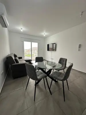 a living room with a glass table and chairs at Oroklini's Flat in Larnaka