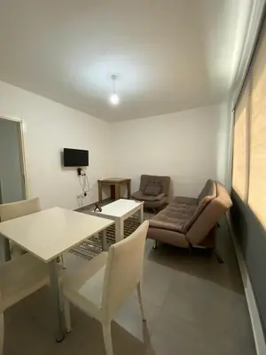 a living room with a couch and a table and chairs at FLAT Ceremi in Nicosia
