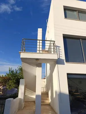 a white building with a balcony on the side of it at FLAT Ceremi in Nicosia