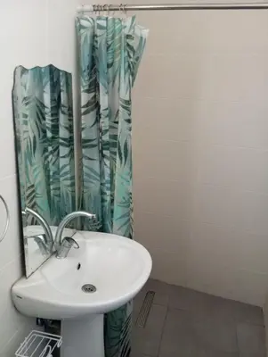 a bathroom with a sink and a shower curtain at FLAT Ceremi in Nicosia