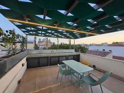 a patio with a green table and chairs on a roof at Green Leaf - Old City Suite in Limassol