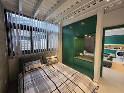 a bedroom with a bed with a green wall at Green Leaf - Old City Suite in Limassol