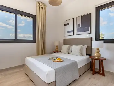 a bedroom with a bed and two windows at Sanders Eduardovich Limassol in Limassol