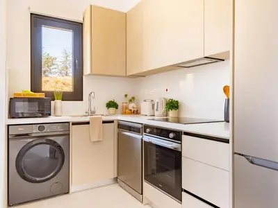 a kitchen with a washer and dryer at Sanders Eduardovich Limassol in Limassol