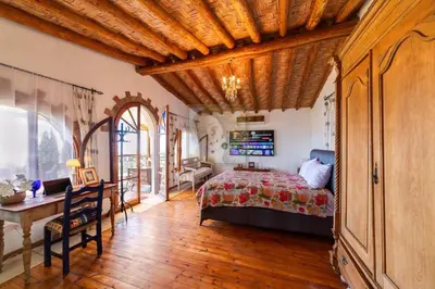 a bedroom with a bed and a wooden ceiling at A historic STONE VILLA with private garden, terrace and private pool just for you in Kérynia